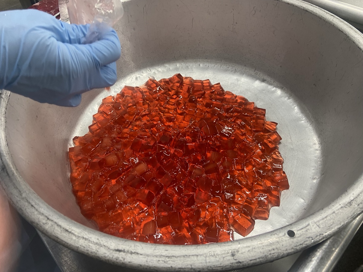 Making celebration jelly in a large pot - red jelly being prepared for grade promotion lunch